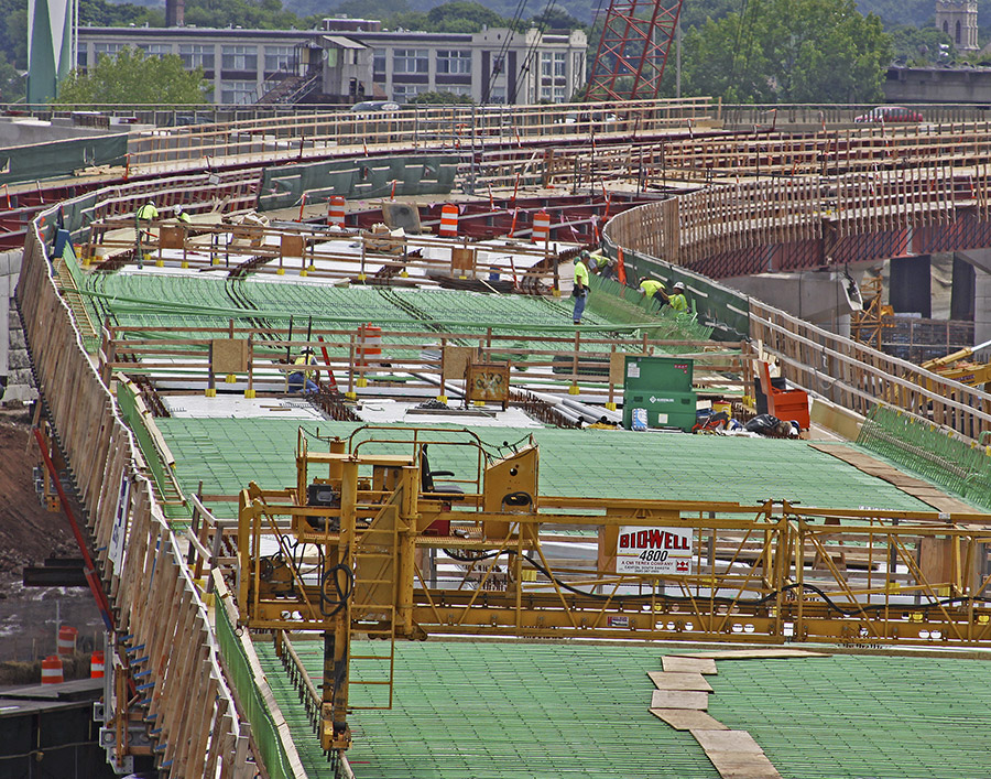 A large raised freeway is staged with rebar cages before concrete is poured.